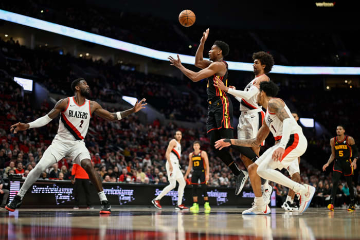 Mar 13, 2024; Portland, Oregon, USA; Atlanta Hawks forward De'Andre Hunter (12) passes the ball during the second half against Portland Trail Blazers guard Matisse Thybulle (4) and center Deandre Ayton (2) at Moda Center. Mandatory Credit: Troy Wayrynen-USA TODAY Sports